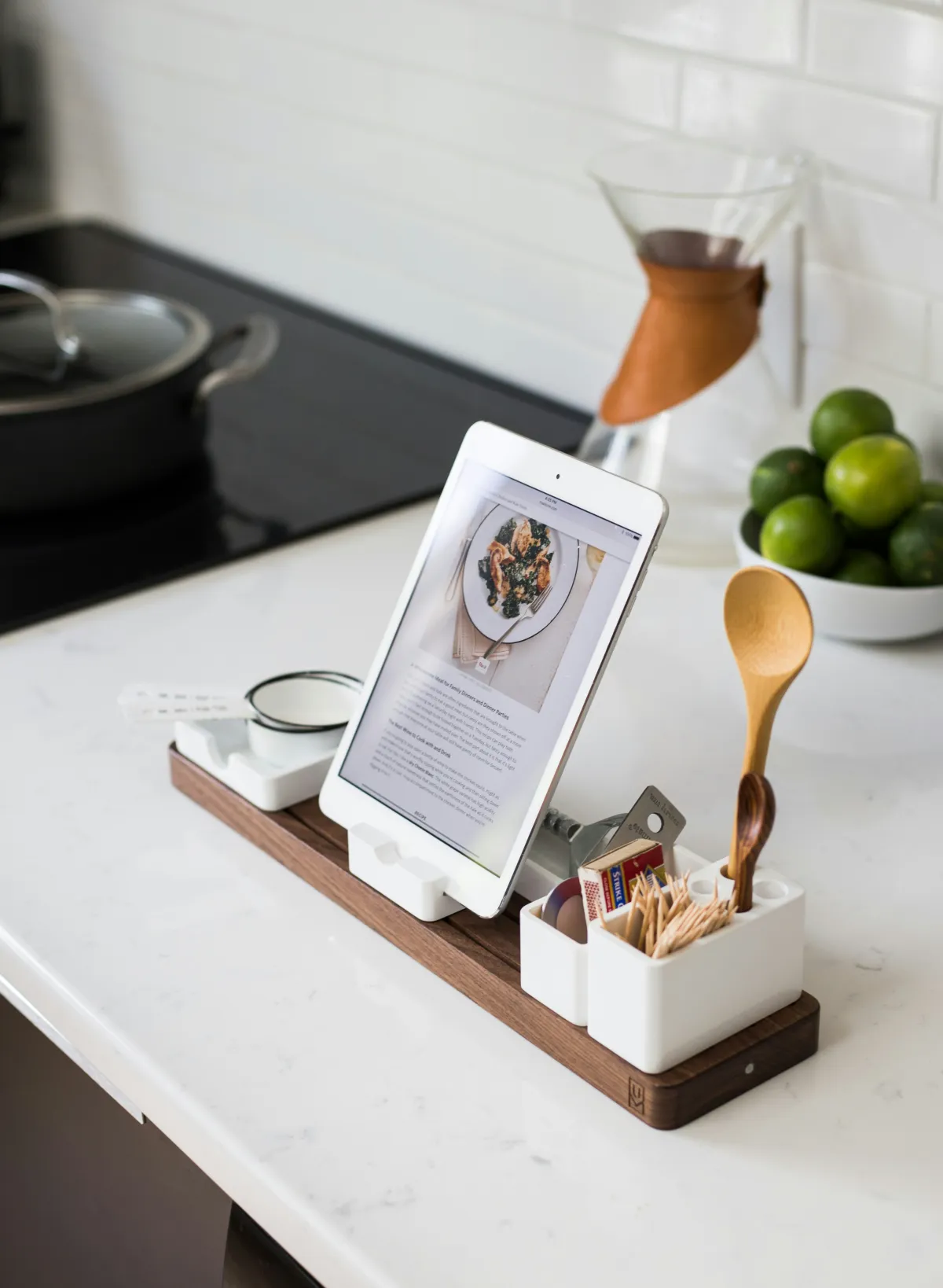 A tablet displaying a recipe on a kitchen counter with a spice rack